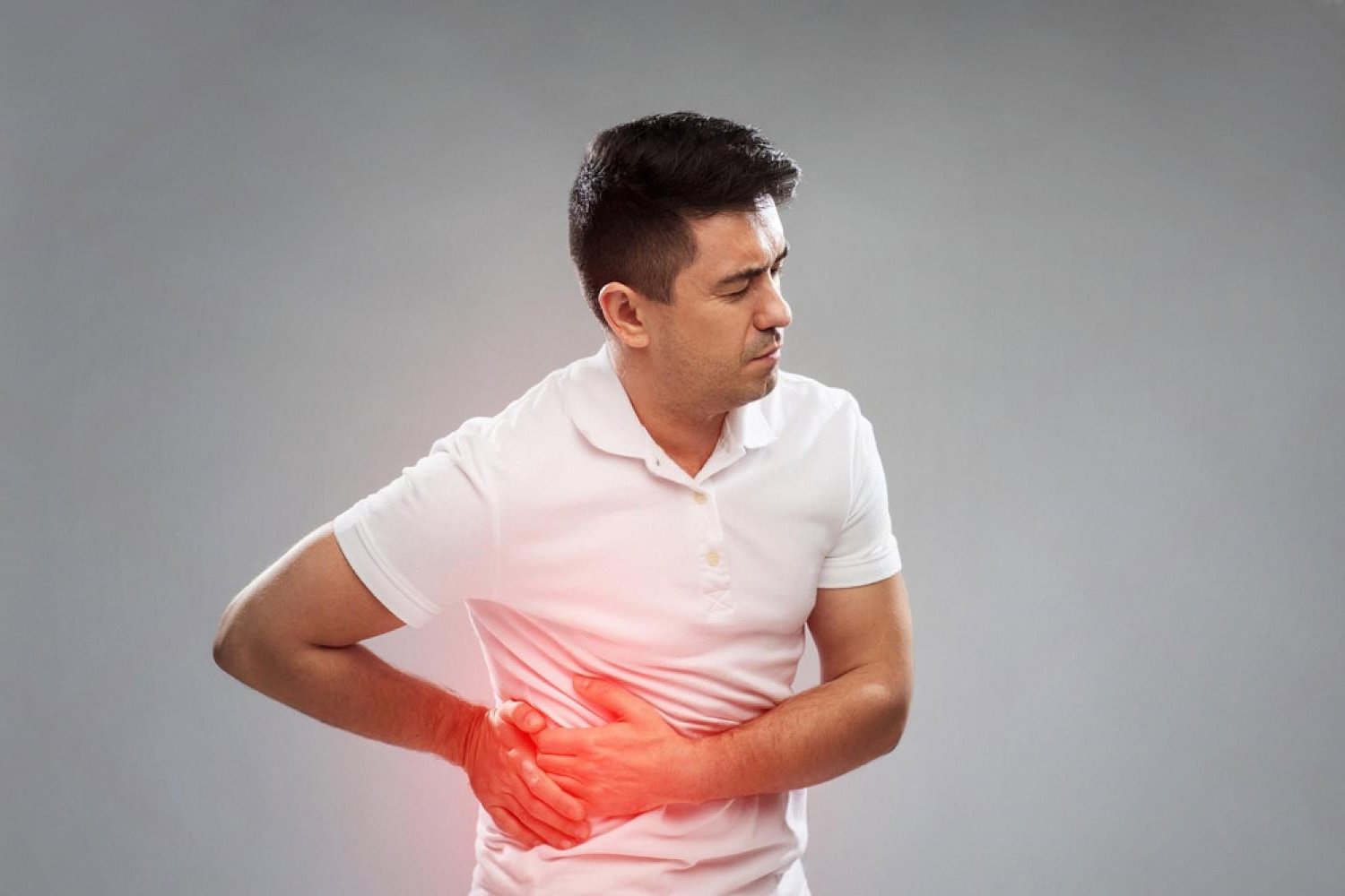Man clutching lower right abdomen showing classic appendicitis pain location